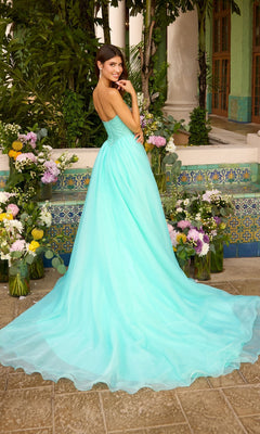 A person wears a strapless, floor-length turquoise Ava Presley 47424 ball gown with a beaded bodice and full skirt, standing among vases of flowers.