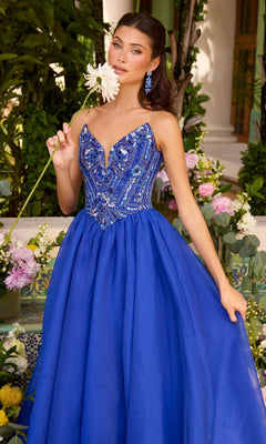 A woman wears an Ava Presley 47430 royal blue strapless sequin prom dress with a heavily beaded bodice and a full, floor-length skirt while holding a white flower.