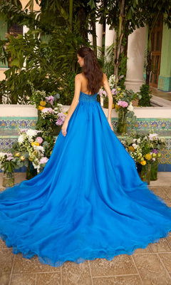 Seen from behind, a woman wears a vibrant blue Ava Presley 47439 prom gown with a strapless bodice and a full, flowing floor-length skirt.
