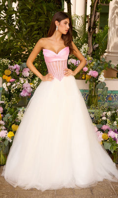 A woman wears an Ava Presley 47484 strapless corset ball gown with a pink bodice and a full white tulle skirt, posed among flower arrangements.