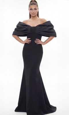A woman wearing the Long Formal Dress: Jovani 47657—a fitted, black, off-the-shoulder gown with voluminous sleeves—stands against a plain white background, channeling sophisticated elegance.