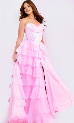 A woman in the Jovani 47762 long prom dress with a strapless satin corset bodice and ruffle-tiered chiffon skirt stands against a white background, holding part of her skirt to the side.