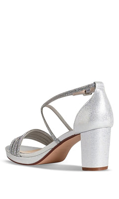 The Tabbie Silver Prom Shoes by Touch Ups 4778 feature a block heel, crystal-embellished crossing front straps, and a closed heel, displayed from a rear side angle.