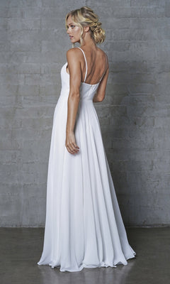 A woman with blonde hair in an updo wears the Simple V-Neck Long A-Line Prom Dress 477, standing sideways and looking over her shoulder against a gray textured wall.