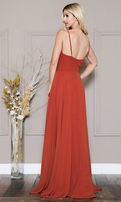 A woman with long blonde hair, seen from behind, wears the Simple V-Neck Long A-Line Prom Dress 477—a sleeveless, floor-length rust gown—standing next to a tall vase of dried plants.