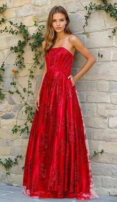 A woman stands before a vine-covered stone wall, wearing the Strapless Glitter Prom Dress Blondie Nites 4792BN in red.