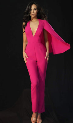 A woman stands against a black background wearing a fuchsia Jovani 48028 one-shoulder cape long jumpsuit with transparent heels.