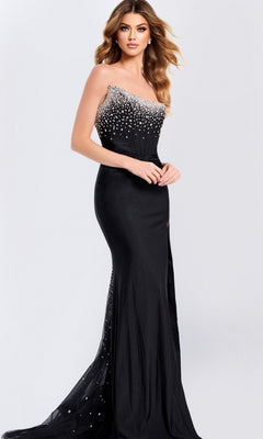 A woman wears the black Strapless Sheer-Corset Prom Gown (Jovani 48122) with a fitted beaded corset bodice, posing against a plain light background.