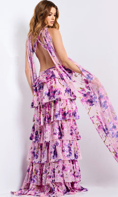 A woman models the Jovani 48234 Long Prom Dress, a sleeveless, backless, floor-length gown with pink and purple floral patterns and layered ruffles, against a plain white background.