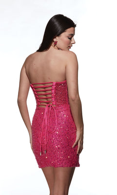 A woman in the Alyce Strapless Sequin Mini Homecoming Dress 4825—pink, sequined, with a lace-up back—stands looking over her shoulder against a white background.