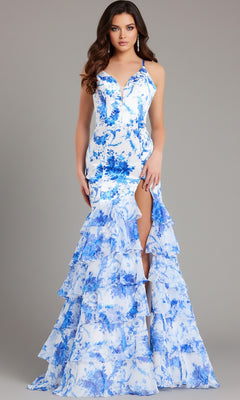 A woman models the Jovani 48331, a blue and white floral long prom dress with a tiered ruffle skirt, thigh-high slit, and lace-up open back, standing against a plain gray background.