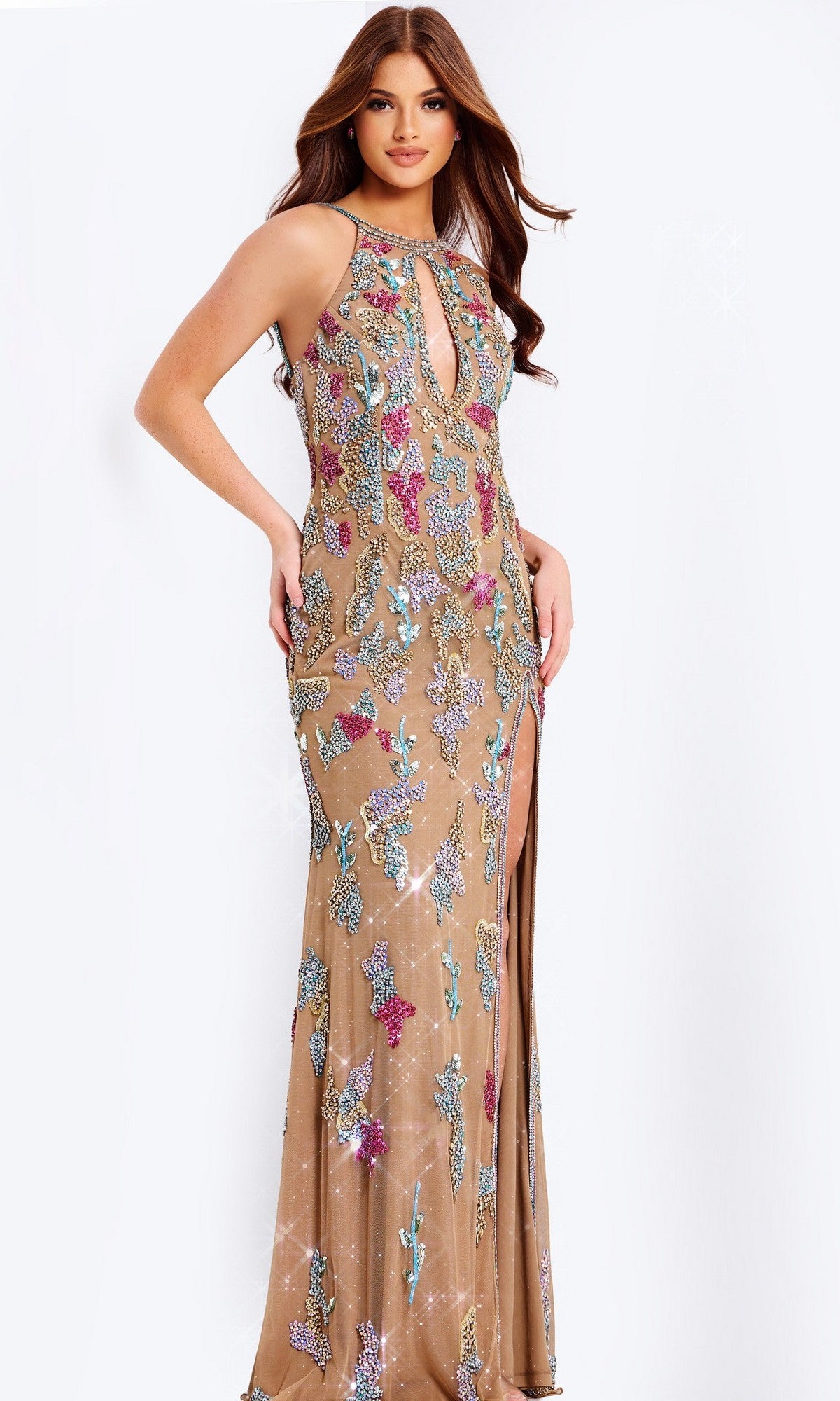 A woman wears the Long Prom Dress: Jovani 48556—a sleeveless nude sheath gown featuring colorful floral sequin embroidery, a front keyhole cutout, and a thigh-high slit.