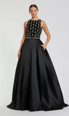 A woman wearing the Mac Duggal 48803 long formal dress, featuring a sleeveless black design with a jewel-embellished bodice and satin A-line skirt, poses against a plain background.
