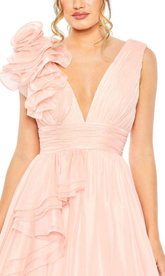 Woman wears the Mac Duggal 48856 Ruffled Long Prom Ball Gown, featuring a sleeveless blush pink design with a deep V-neckline and ruffled accents on one shoulder and along the skirt.