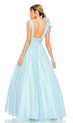 A woman in the Mac Duggal 48856 Ruffled Long Prom Ball Gown, light blue and floor-length, with an A-line silhouette, open back, and bow detail, stands facing away.