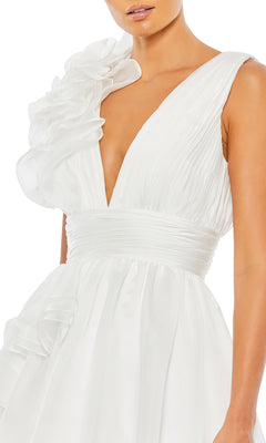 A woman wears the Mac Duggal 48856 Ruffled Long Prom Ball Gown, a sleeveless white evening dress featuring a deep V-neck and ruffled one-shoulder detailing.