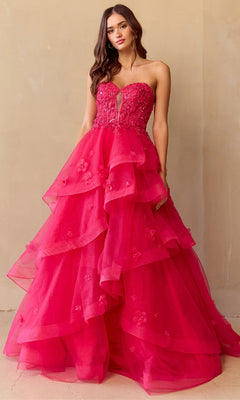 Woman wearing a hot pink strapless ball gown with ruffled layers on a beige background