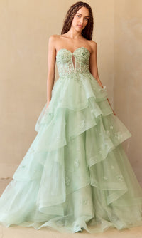 Woman wearing a light green strapless ball gown with floral details against a beige background