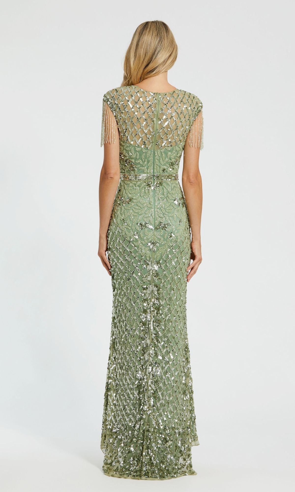 A woman faces away, wearing the Cap-Sleeve Beaded Formal Gown: Mac Duggal 4908—a floor-length, light green sequined evening dress with a sheer back and short beaded fringe sleeves.