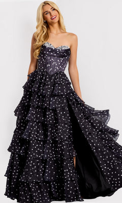 A woman in the Jovani 49087 long prom dress, featuring a strapless design with polka dots and tiered ruffle layers, stands against a plain background.