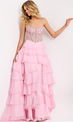 A woman stands against a plain white background wearing the Jovani 49109 long prom dress in light pink, featuring a strapless beaded corset bodice and a layered chiffon skirt.