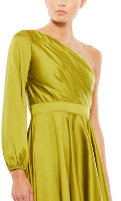 A woman wears the Mac Duggal 49141 One-Sleeve High-Low Prom Dress, featuring shiny light green fabric, a one-shoulder design with a single long sleeve, and gathered details at the waist and shoulder.
