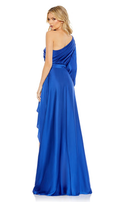 A woman models the Mac Duggal 49141 One-Sleeve High-Low Prom Dress in royal blue satin, standing slightly turned and looking over her shoulder.