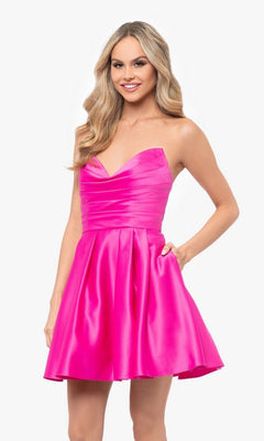 Woman in the Short Strapless Sweetheart Hoco Dress 4914BN, a bright pink, strapless mini dress with a ruched waist, flared skirt, and side pockets, standing against a white background.