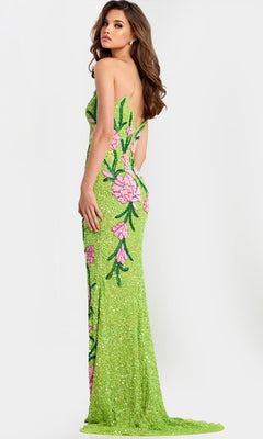 A woman poses with her back and side to the camera against a plain light background, wearing the Jovani 49231 long prom dress in lime green with pink floral designs.