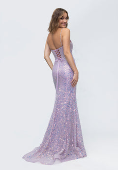 A woman smiles over her shoulder wearing the Morilee 49236, a sparkly, light purple long prom dress with thin straps and a sequin-embroidered tulle skirt.