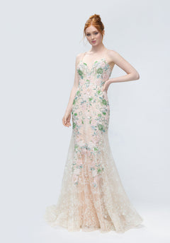 Model wearing the Morilee 49244 long prom dress, a fitted, floor-length mermaid gown with sheer fabric, floral embroidery, and lace details, standing against a plain light background.
