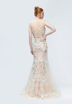 A woman with red hair in an updo wears the Morilee 49244 long prom dress—a backless, floor-length gown with thin straps and floral lace—standing against a plain light background.