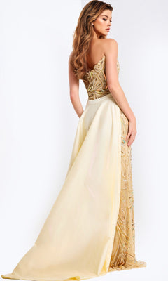 A woman in the Jovani 49255 long prom dress, featuring a strapless gold-embellished beaded bodice and an attached cream train, stands sideways and glances over her shoulder.