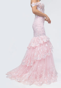 Woman wearing Morilee 49274, a light pink off-shoulder lace corset gown featuring sequin details and a layered ruffle skirt.