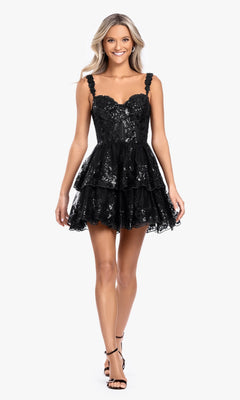 A woman in the Short Ruffled Hoco Dress: Blondie Nites 4931BN in black, featuring sequins, thin straps, and a tiered mini silhouette, stands against a white background wearing black strappy heels—perfect for homecoming.