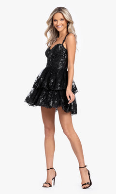 A woman stands against a plain white background wearing the Blondie Nites 4931BN Short Ruffled Hoco Dress and black high-heeled sandals. The dress is sleeveless, black, party-ready, with sequin embellishments and thin straps.