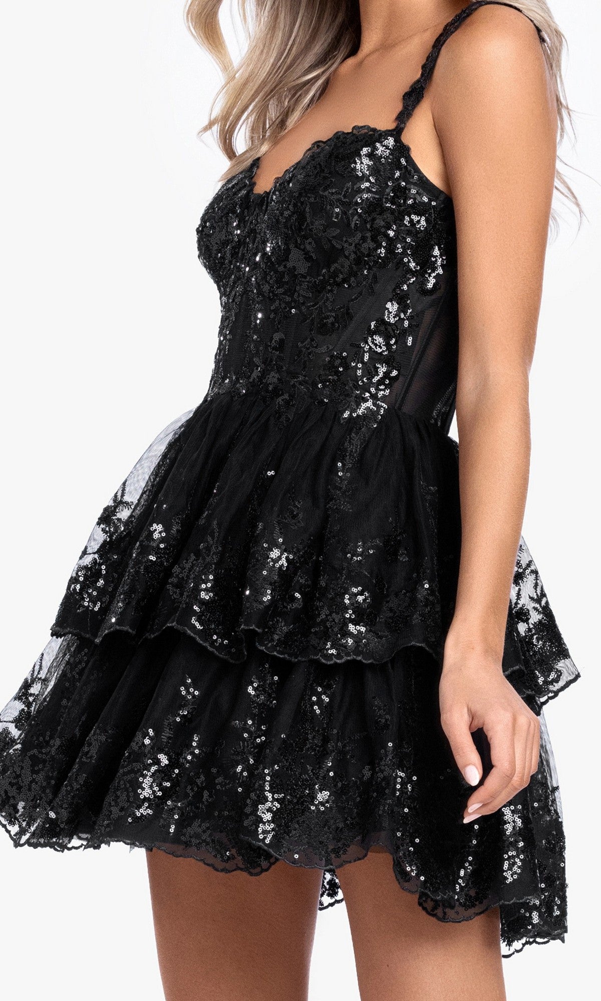 Woman wearing the Short Ruffled Hoco Dress by Blondie Nites 4931BN—a black, sleeveless, fitted party dress with sequin embellishments and a layered ruffled skirt.
