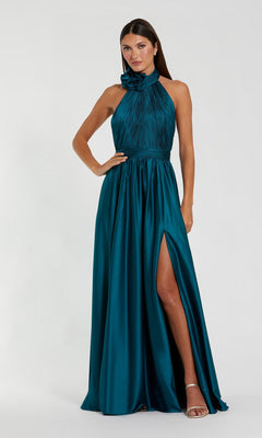 A woman stands against a plain background wearing the Mac Duggal 49333 High-Neck Halter Formal Dress in teal, featuring a floor-length design, pleated bodice, floral details, high neckline, and thigh-high slit.