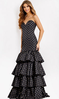 A woman models the Jovani 49419 long prom dress, a strapless mermaid gown with gold polka dots and tiered ruffle layers, standing against a plain white background.