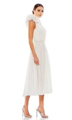 A woman models the Mac Duggal 49491 knee-length white party dress with a one-shoulder ruffle detail and silver high heels, posed against a white background.