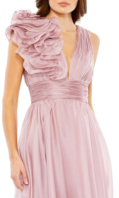 A woman wearing the Mac Duggal 49494 short ruched wedding-guest dress, featuring a sleeveless design, deep V-neckline, pleated bodice, wide waistband, and a striking one-shoulder ruffle detail.