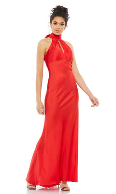 A woman stands against a white background wearing the Long Formal Dress 49520 by Mac Duggal—a floor-length, sleeveless red halter gown with a high neck and keyhole detail.