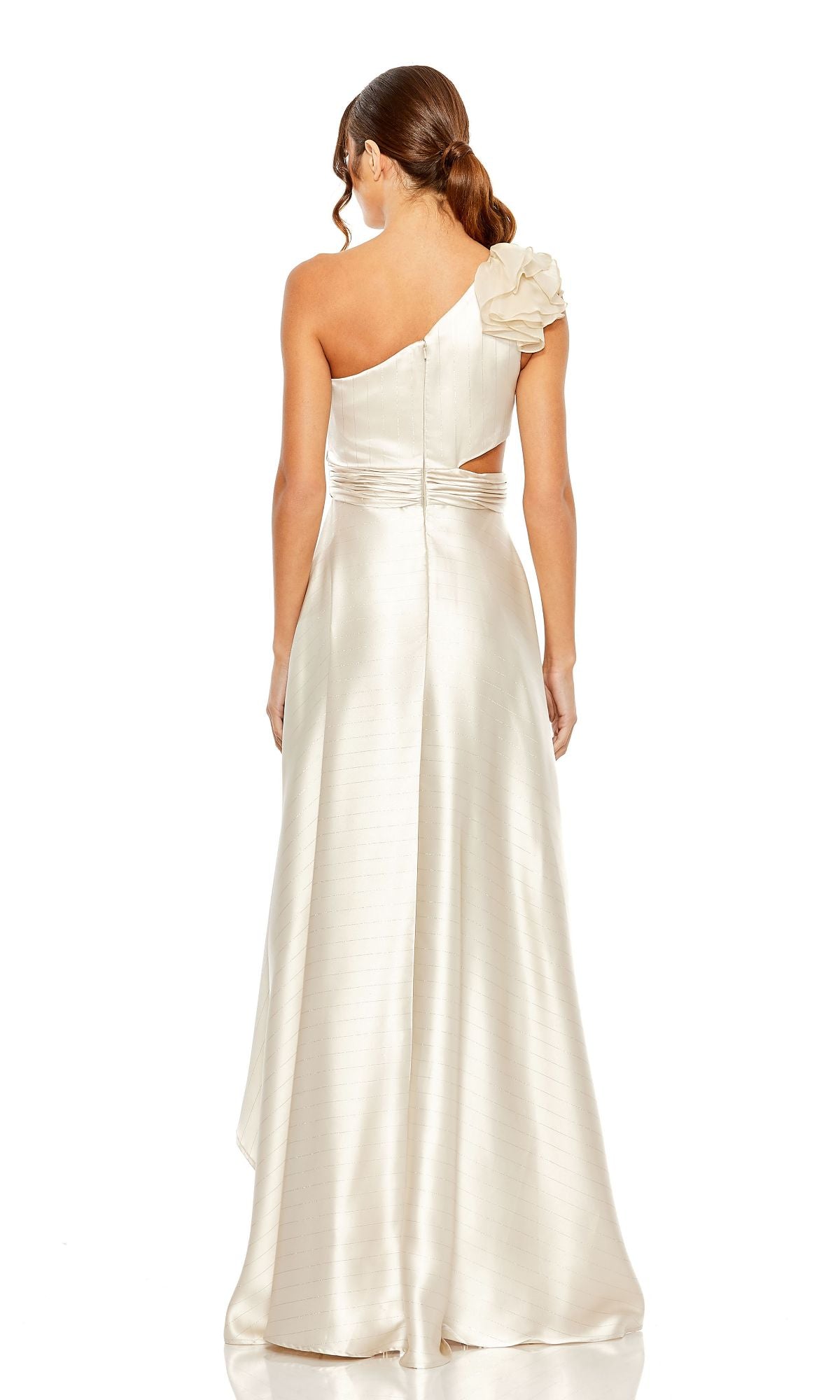A woman in the Mac Duggal 49523 one-shoulder wedding guest dress, featuring an ivory high-low hem and ruffle detail, stands facing away to display the elegant back of the gown and her wavy ponytail.