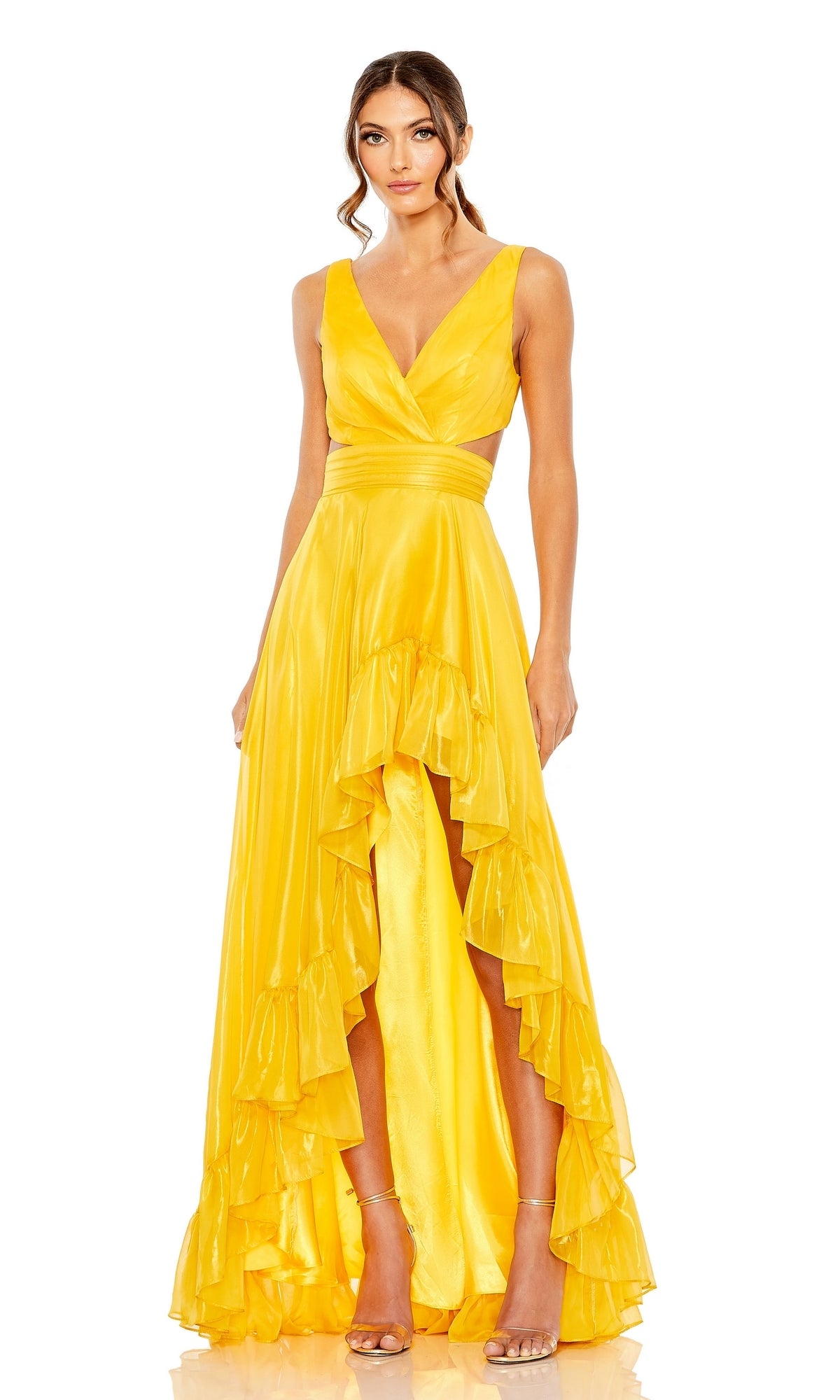 A woman wearing the Mac Duggal 49526 Ruffled High-Low Formal Dress in yellow, featuring a sleeveless design, deep V-neckline, and high-low hem with ankle-strap heels, stands against a white background.