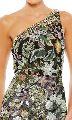A woman wears the Mac Duggal 49574 One-Shoulder Sequin Formal Dress featuring intricate floral embroidery and sequin detailing in green, pink, yellow, and white.