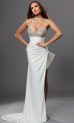 A woman wearing the Jovani 49577 long formal dress—a white, strapless crepe gown with silver sequin detailing and a thigh-high slit, exuding signature column elegance—stands against a plain gray background.