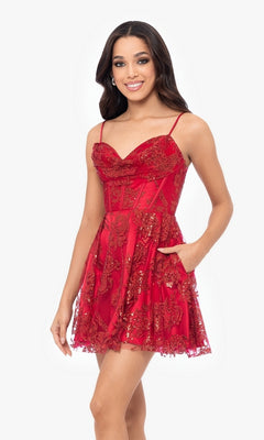 A woman models the Short Red Glitter Homecoming Dress 4960BN, featuring sequin embroidery and spaghetti straps, against a plain white background.