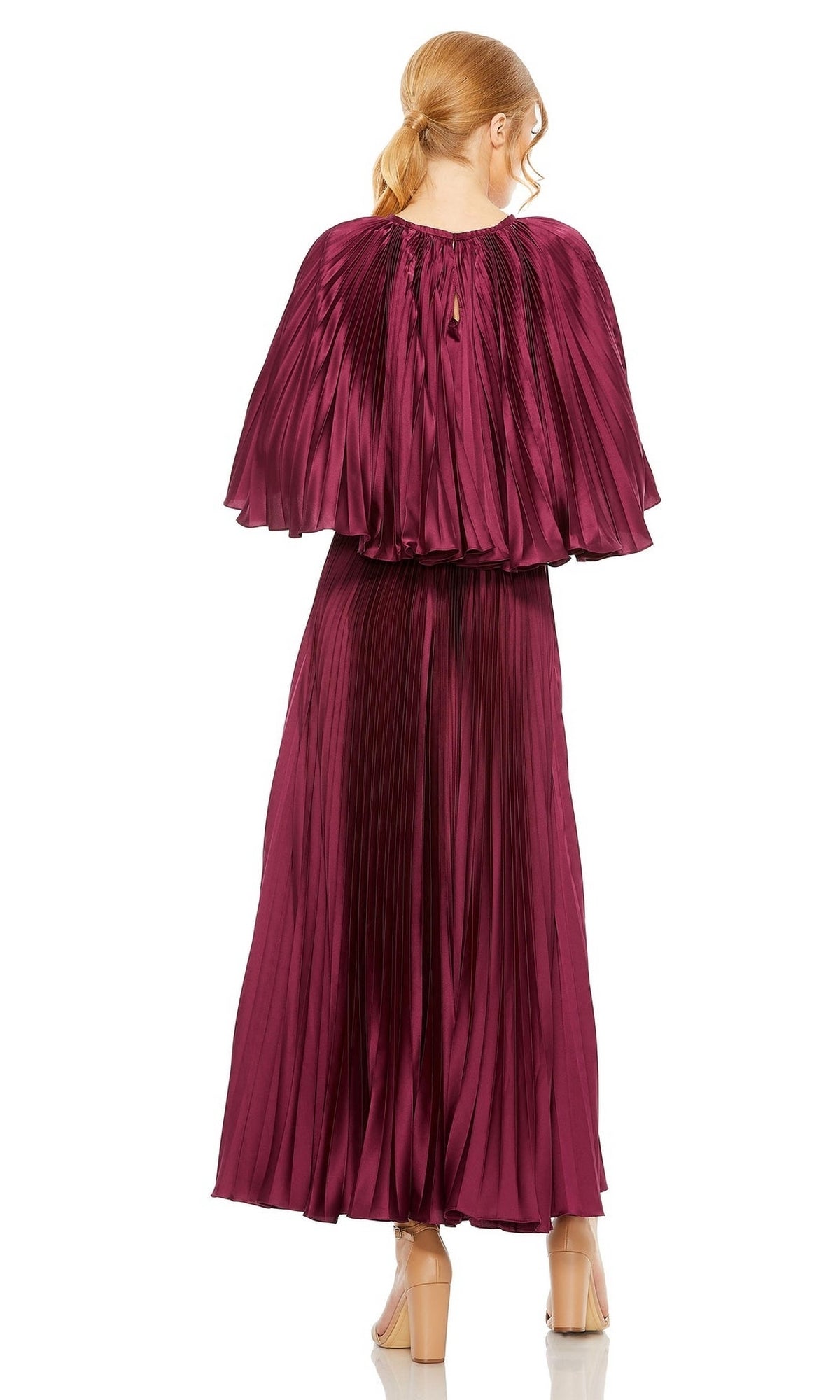 A woman with blonde hair in a low ponytail wears the Mac Duggal 49638 Caped Tea-Length Party Dress in shiny magenta, featuring pleats and an ankle-length skirt, paired with nude heels. She faces away from the camera.
