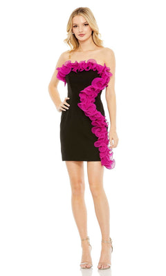 A woman wears the Short Homecoming Dress 49642 by Mac Duggal, a strapless black party dress with bold pink ruffle detail along the top and side, paired with strappy heels.