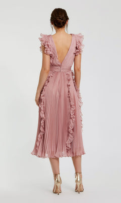 A woman stands with her back to the camera in the rose pink Short Wedding Guest Dress 49675 by Mac Duggal, featuring chiffon fabric, ruffle cap sleeves, a pleated hem, and paired with gold high-heeled shoes.